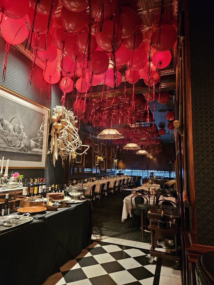 Red helium balloon ceiling installation in a Houston restaurant