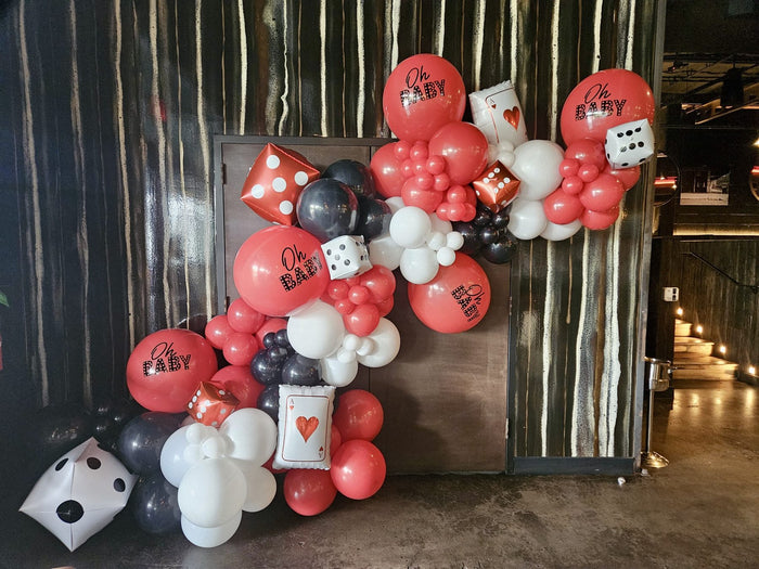 Casino night balloon garland in red, black and white with dice and card balloons