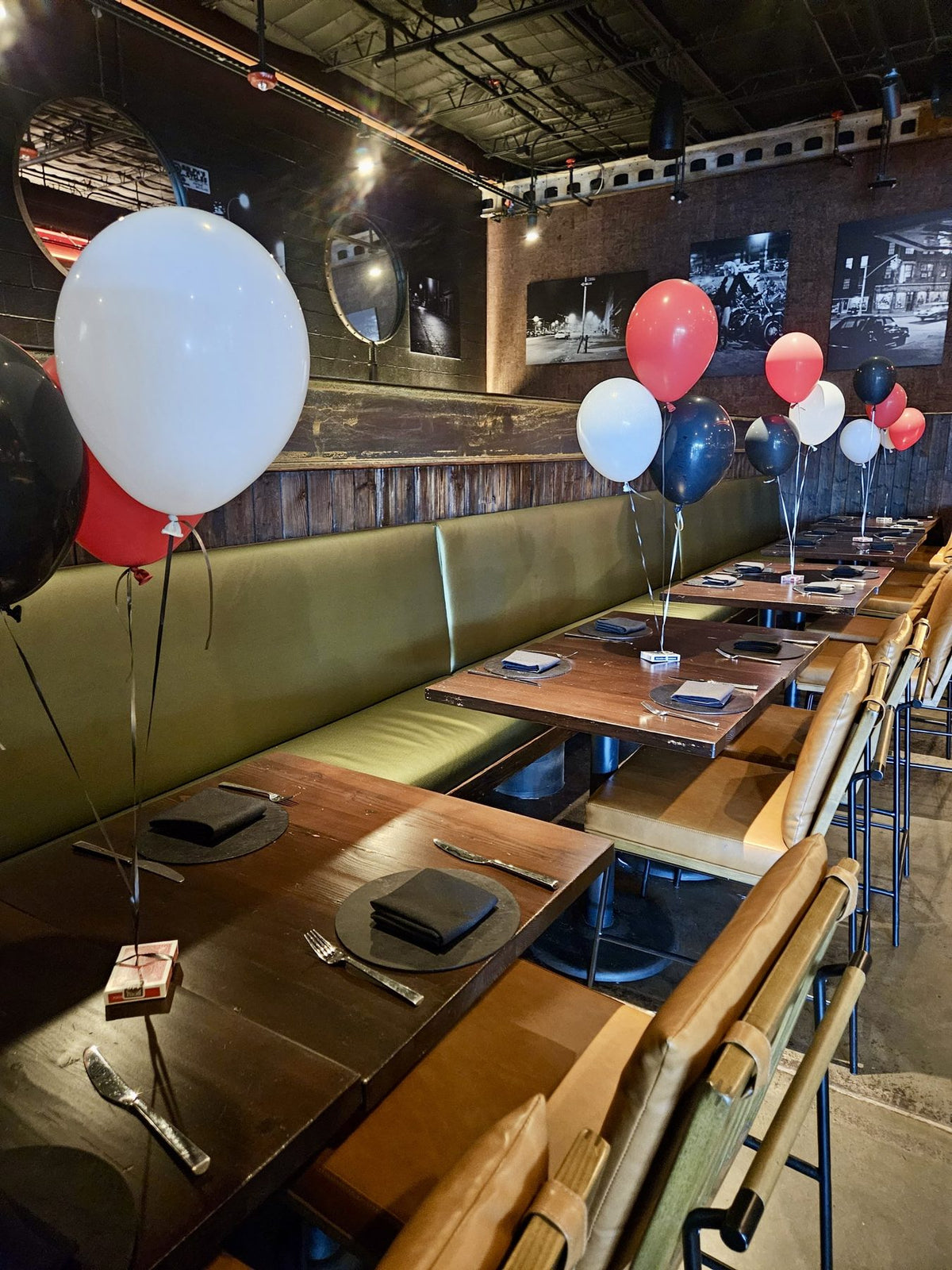 Helium balloon bundles on ribbon as table decor at a Houston restaurant event