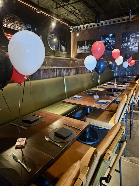 Helium balloon bundles on ribbon as table decor at a Houston restaurant event